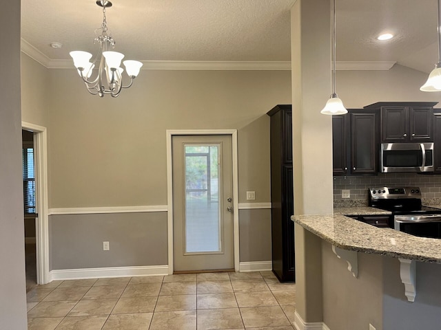 kitchen featuring appliances with stainless steel finishes, light stone counters, decorative light fixtures, an inviting chandelier, and a breakfast bar area