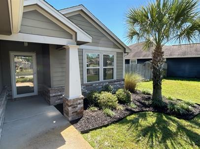 view of exterior entry with a lawn