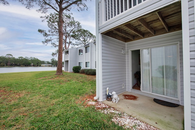 view of property exterior with a water view and a yard