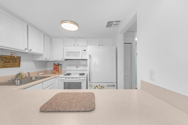 kitchen with tasteful backsplash, white cabinetry, white appliances, and sink