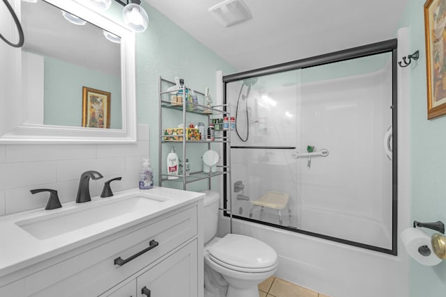 full bathroom featuring tile patterned flooring, shower / bath combination with glass door, vanity, toilet, and decorative backsplash