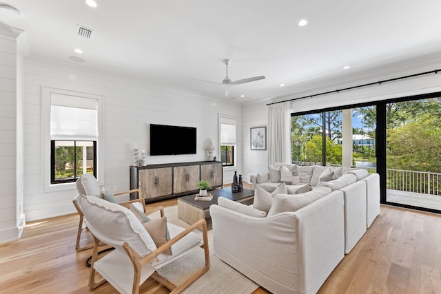 living room with ornamental molding, ceiling fan, and light hardwood / wood-style floors