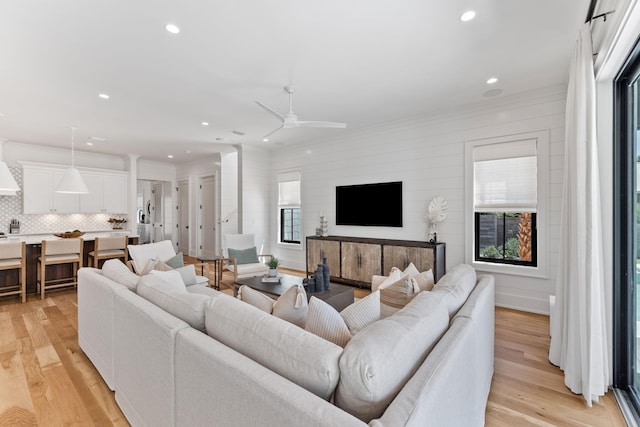 living room featuring ceiling fan and light hardwood / wood-style flooring