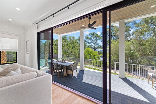 doorway to outside featuring wood-type flooring and ceiling fan