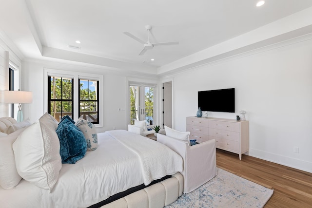 bedroom featuring hardwood / wood-style flooring, ceiling fan, and a raised ceiling