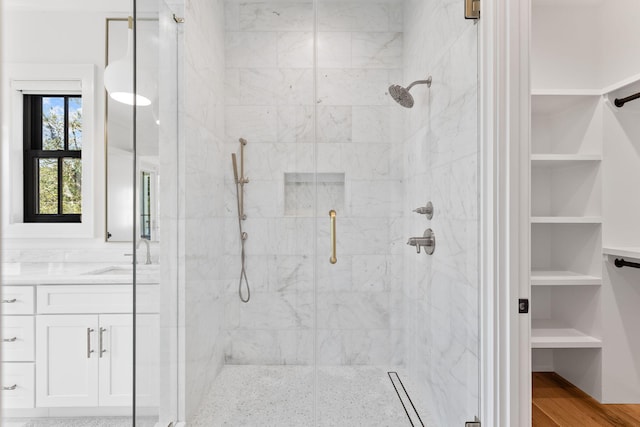 bathroom featuring vanity, hardwood / wood-style flooring, and a shower with door