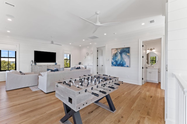 playroom with ceiling fan and light hardwood / wood-style flooring