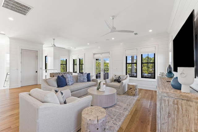 living room with light wood-type flooring and crown molding