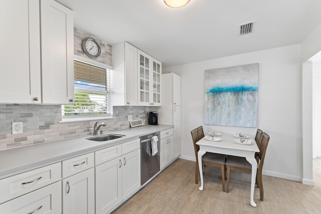 kitchen featuring tasteful backsplash, sink, light hardwood / wood-style floors, white cabinets, and dishwasher