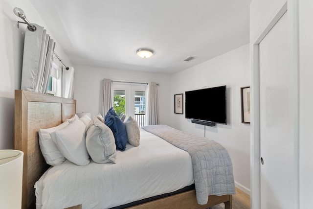 bedroom with french doors and wood-type flooring