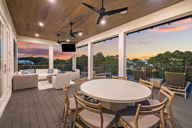 deck at dusk with ceiling fan and an outdoor living space