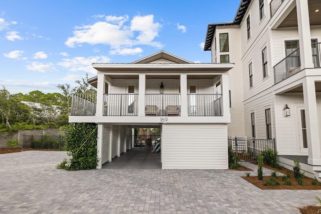 view of front of property featuring a balcony and a carport