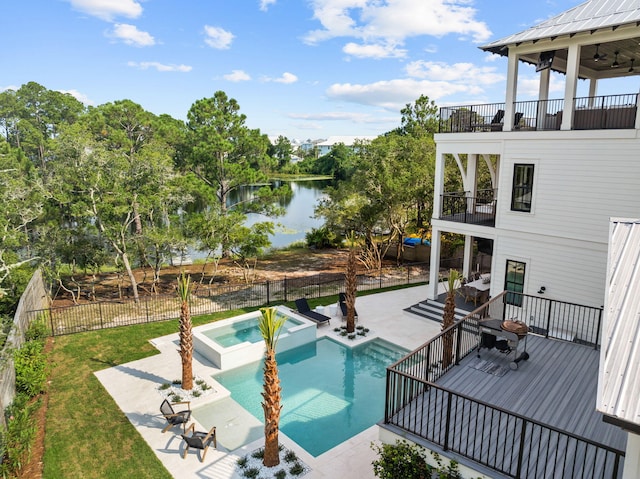 view of pool featuring a yard, a water view, an in ground hot tub, and a patio area