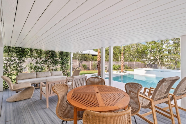 wooden terrace featuring an outdoor living space and a fenced in pool