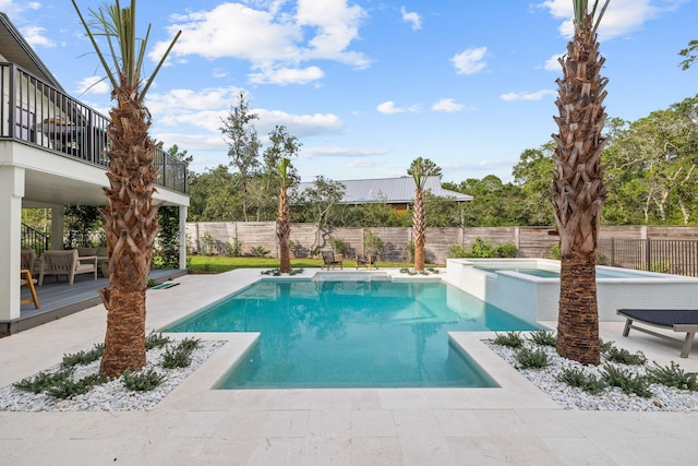 view of pool with a patio, a wooden deck, and an in ground hot tub