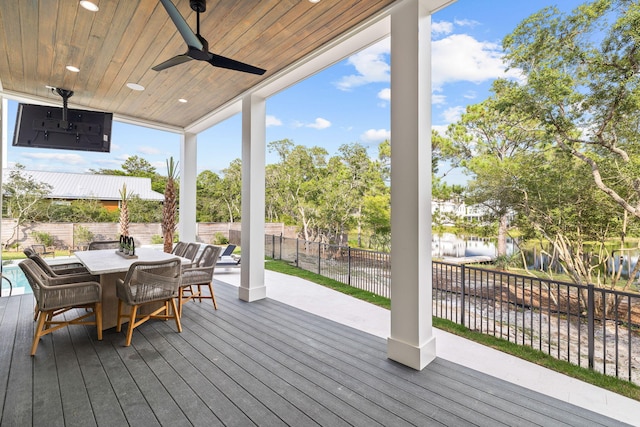 wooden terrace with a water view and ceiling fan