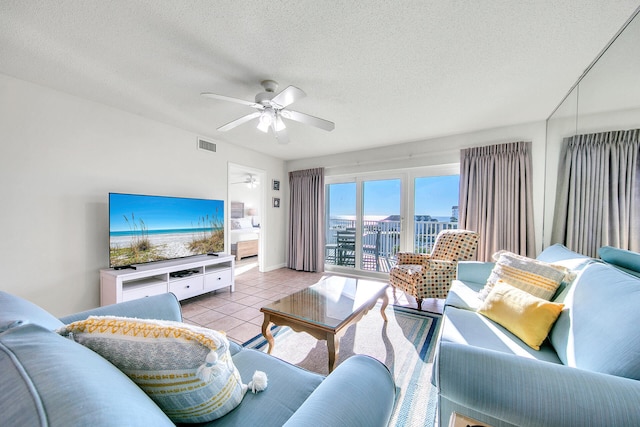 tiled living room featuring ceiling fan and a textured ceiling