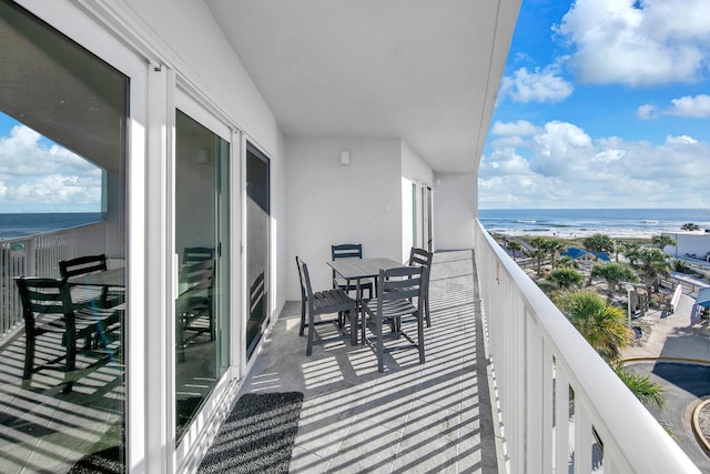 balcony featuring a water view and a view of the beach