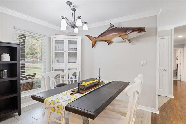 dining space with ornamental molding, a chandelier, and wood-type flooring