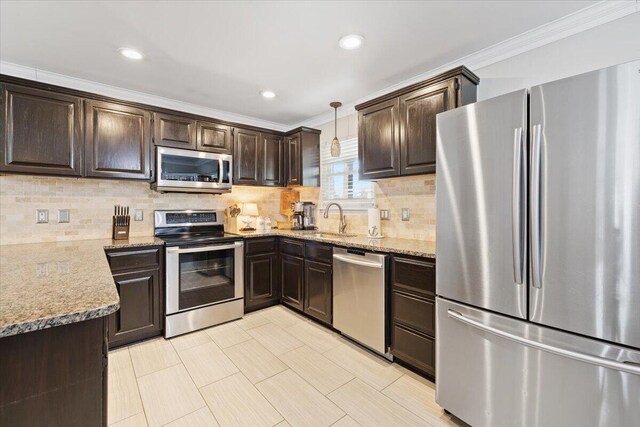 kitchen with sink, tasteful backsplash, crown molding, hanging light fixtures, and appliances with stainless steel finishes