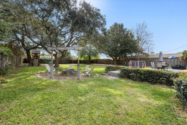 view of yard with a playground and a fire pit