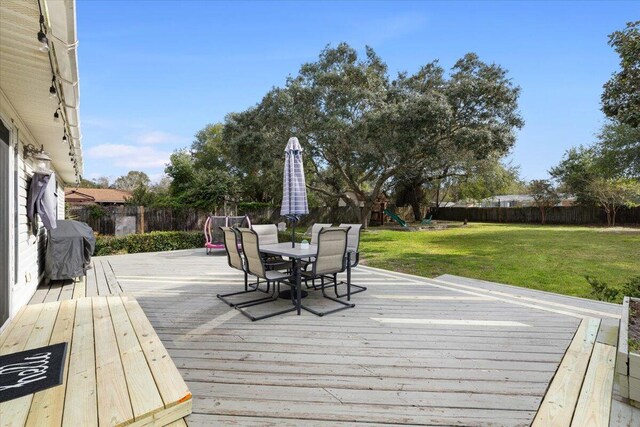 deck with a playground and a lawn