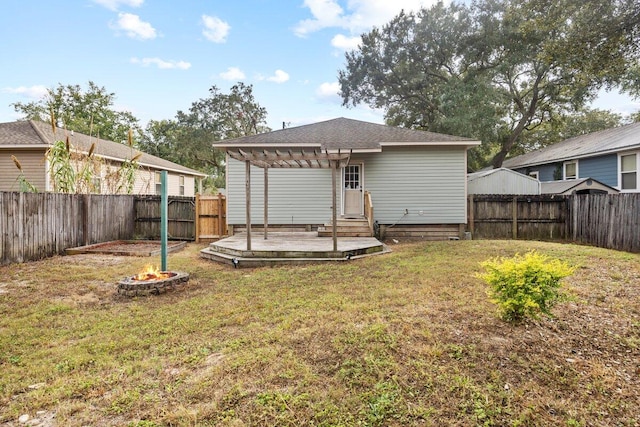 back of property with an outdoor fire pit, a pergola, a lawn, and a deck