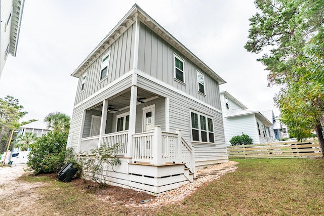 back of property featuring ceiling fan and a lawn