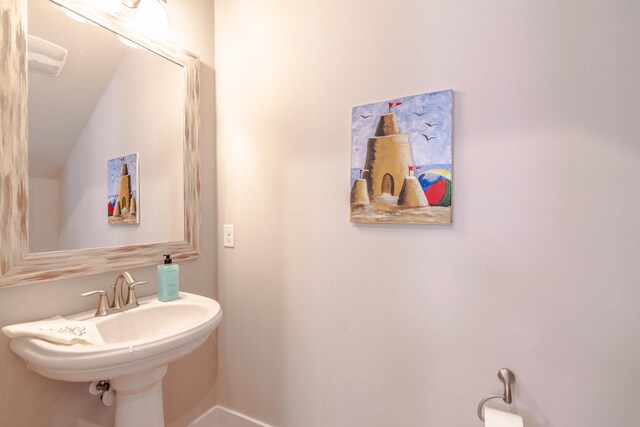 bathroom with lofted ceiling and sink