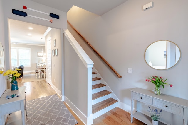 stairway featuring crown molding and hardwood / wood-style flooring