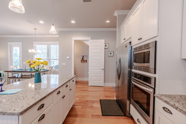 kitchen with white cabinetry, stainless steel appliances, hanging light fixtures, and light hardwood / wood-style flooring