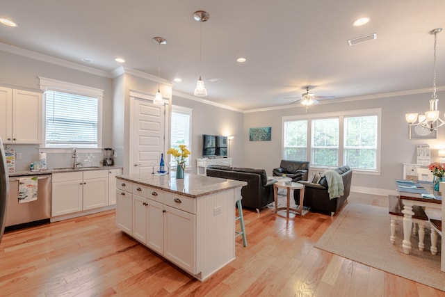 kitchen featuring white cabinetry, stainless steel dishwasher, pendant lighting, light hardwood / wood-style floors, and a kitchen island