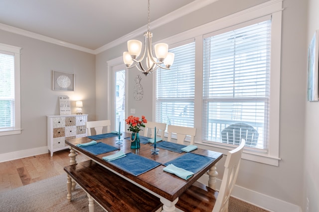 dining space with hardwood / wood-style flooring, ornamental molding, and a wealth of natural light