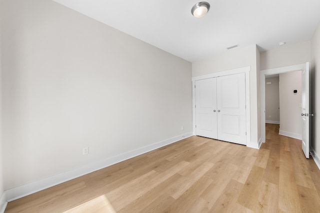 unfurnished bedroom featuring light wood-type flooring and a closet