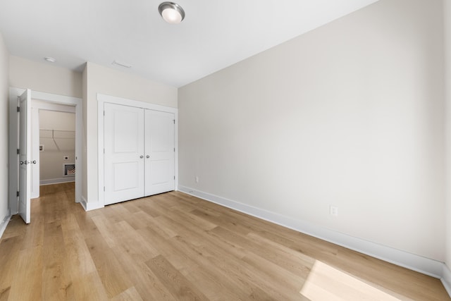 unfurnished bedroom with light hardwood / wood-style flooring and a closet