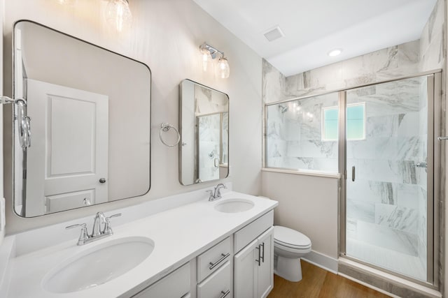 bathroom featuring hardwood / wood-style floors, vanity, toilet, and walk in shower