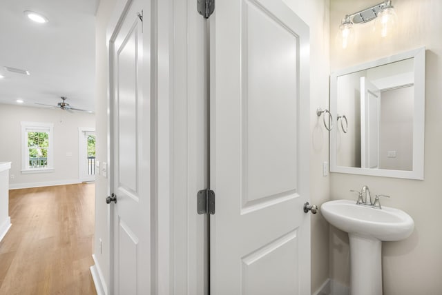 bathroom with ceiling fan, sink, and wood-type flooring