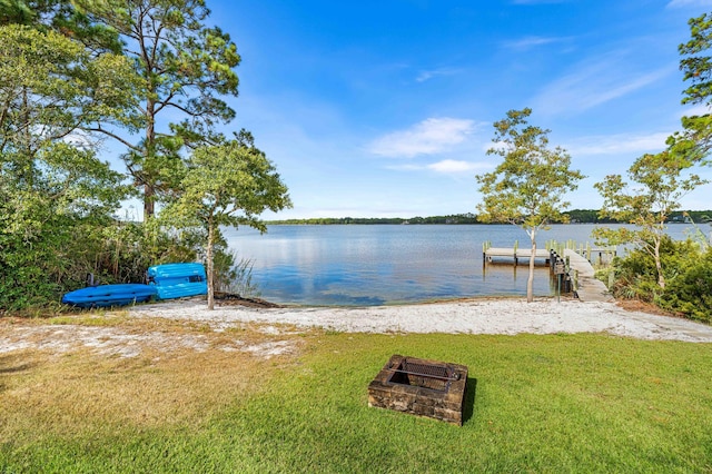 view of dock with a water view and a yard