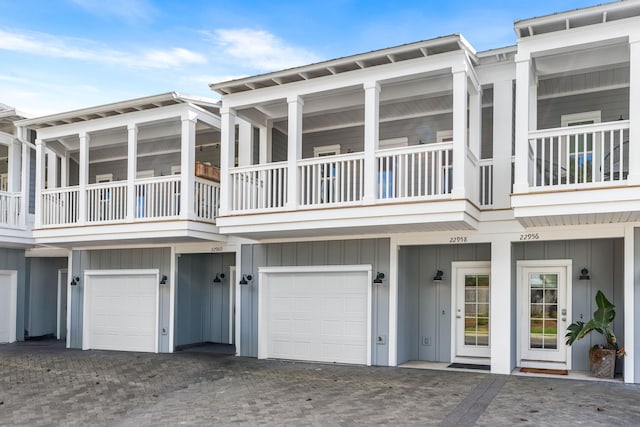 22958 Ann Miller Rd, Panama City Beach, FL 32413 - back of property featuring a garage, board and batten siding, a balcony, and driveway
