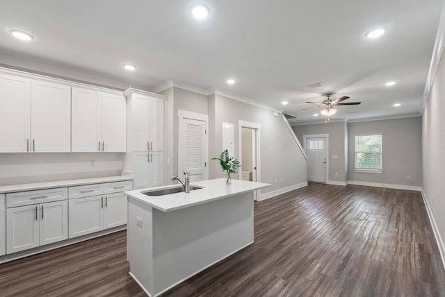 kitchen with white cabinets, ornamental molding, dark wood-type flooring, and sink