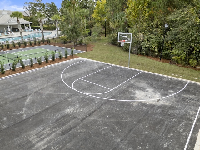 view of basketball court with a community pool and a yard