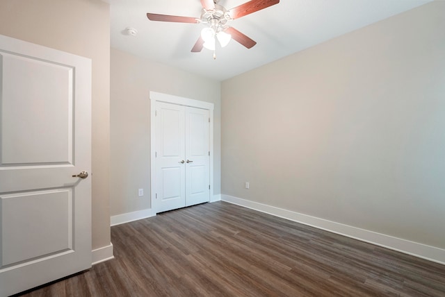 unfurnished bedroom featuring ceiling fan and dark hardwood / wood-style floors