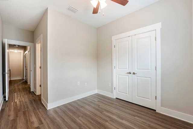 unfurnished bedroom with hardwood / wood-style floors, ceiling fan, and a closet