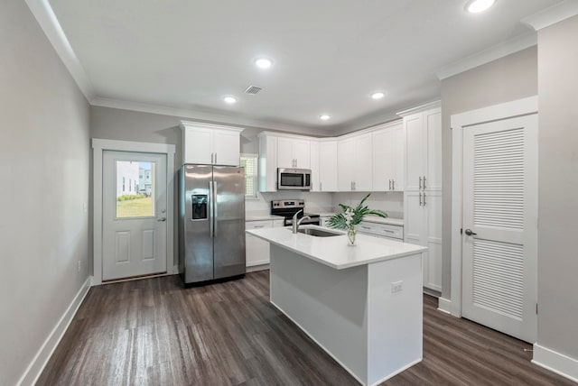 kitchen with stainless steel appliances, dark wood-type flooring, white cabinets, an island with sink, and ornamental molding