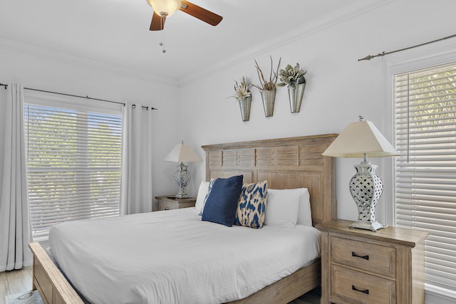 bedroom featuring crown molding, light wood-type flooring, multiple windows, and ceiling fan