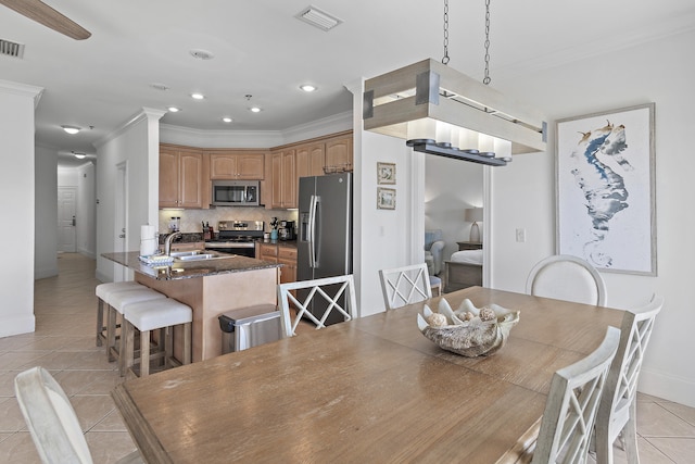 dining room with ornamental molding, light tile patterned floors, and sink