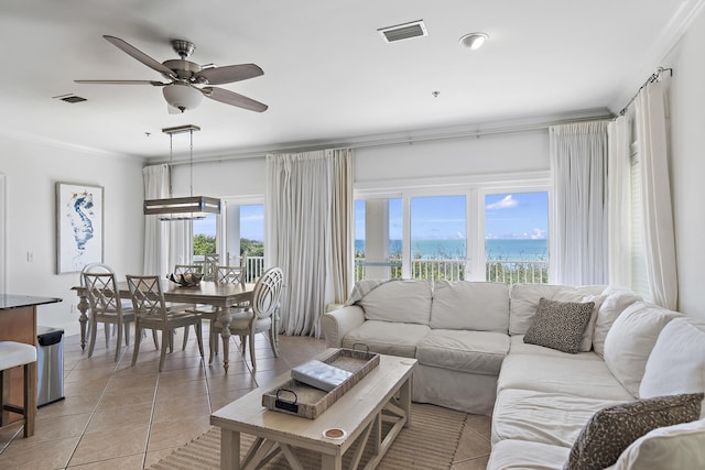 tiled living room with plenty of natural light, a water view, ceiling fan, and crown molding