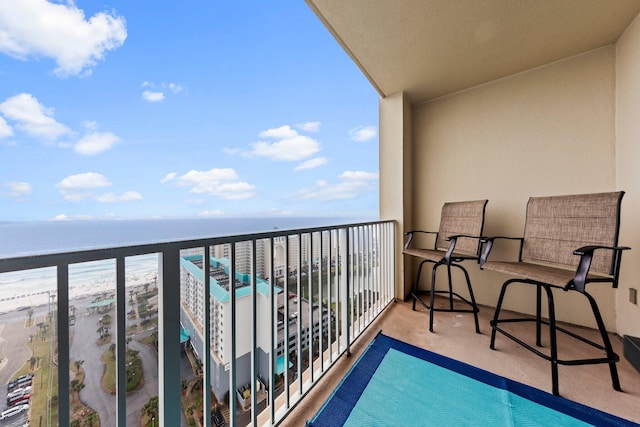 balcony with a water view and a view of the beach