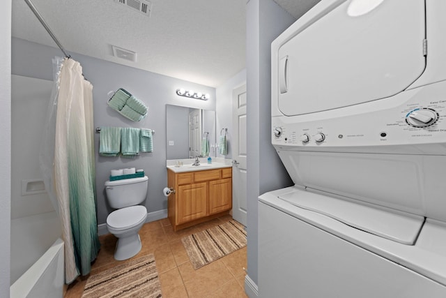 full bathroom featuring shower / bath combination with curtain, stacked washing maching and dryer, vanity, tile patterned floors, and toilet