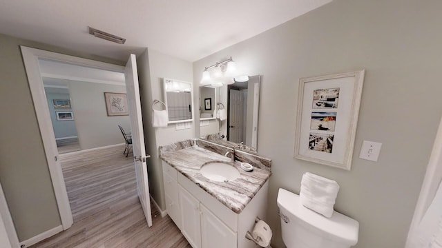 bathroom with vanity, hardwood / wood-style flooring, and toilet